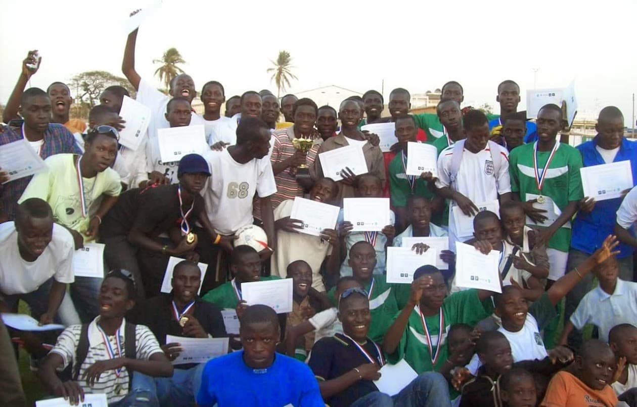 A large group of young players holding certificates and medals at an academy presentation
